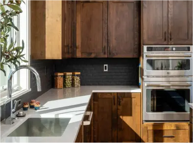 View of beautifully modeled kitchen sink with clean wooden shelving and light colored countertops.